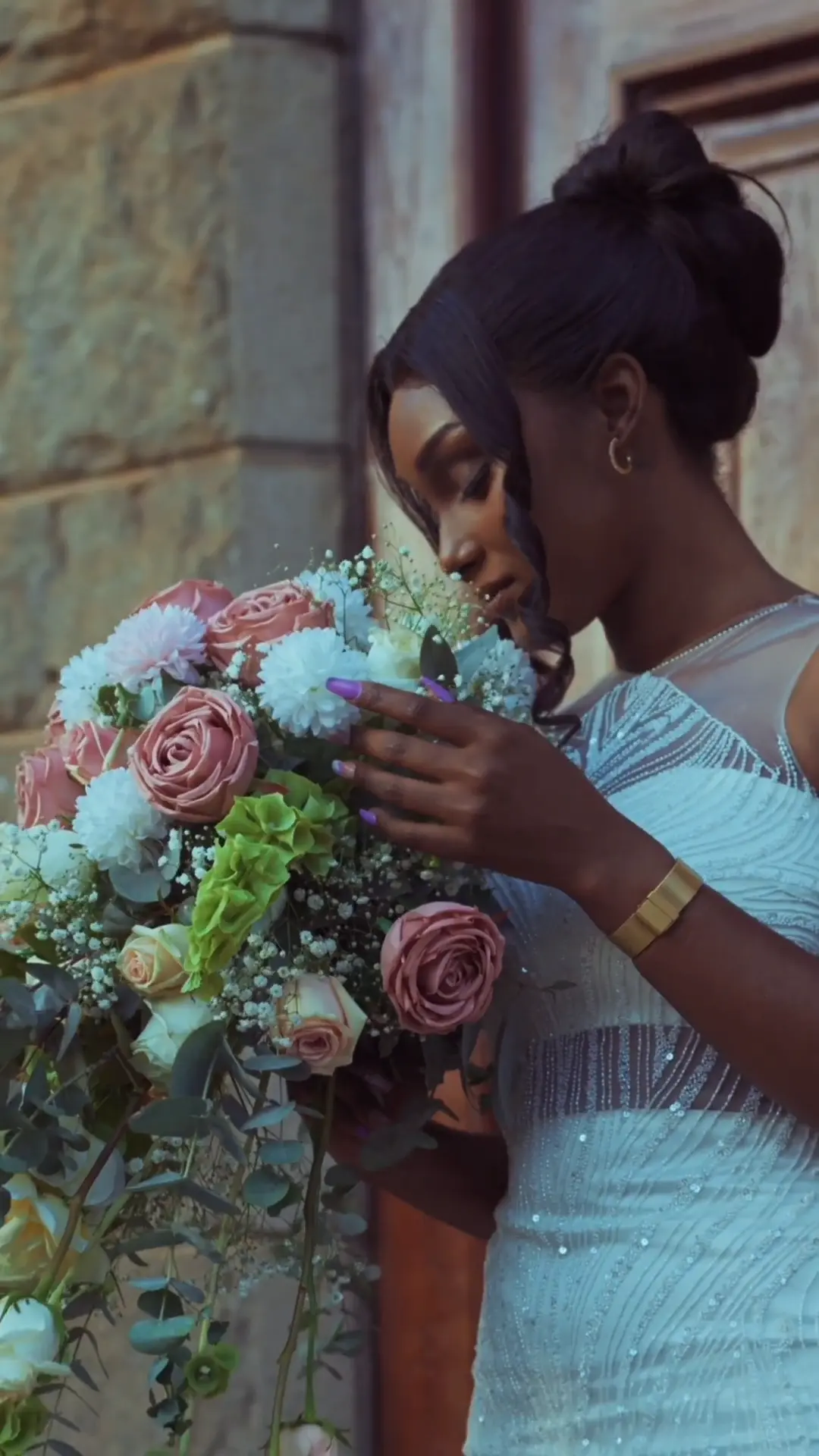 Bride breathing in a cascading bouquet of blush roses, white blooms and trailing greenery